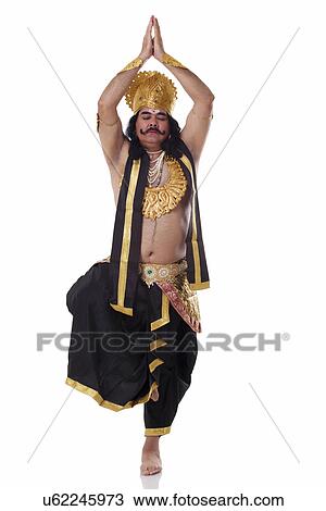 Stock Image - Man dressed as Raavan in yoga pose . Fotosearch