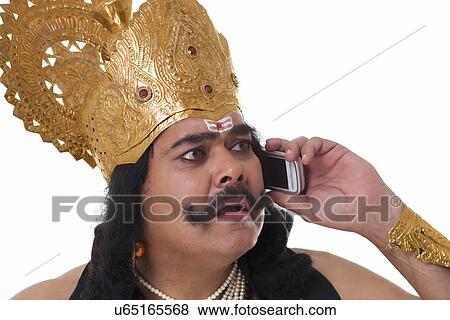 Stock Photo - Man dressed as Raavan talking on a mobile phone . Fotosearch