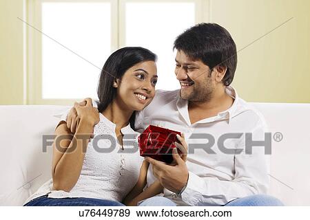 Man giving a gift to his wife View Large Photo Image Stock Photo - Man giving a gift to his wife . Fotosearch