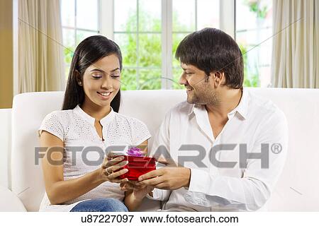 Man giving a gift to his wife View Large Photo Image Stock Photo - Man giving a gift to his wife . Fotosearch