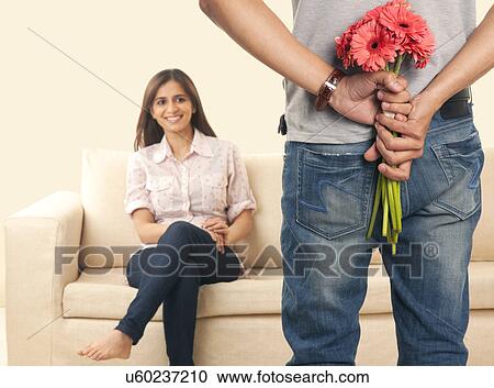 Man hiding flowers from his wife View Large Photo Image Stock Image - Man hiding flowers from his wife . Fotosearch