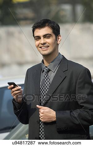 Man holding a mobile phone View Large Photo Image Stock Photo - Man holding a mobile phone . Fotosearch