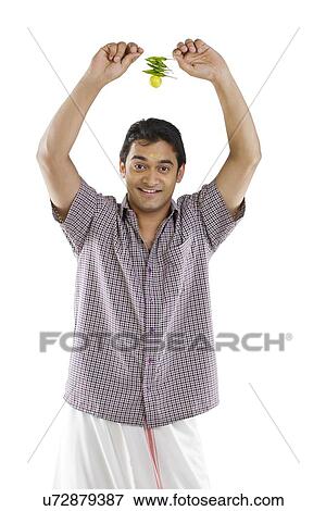Stock Photo - Man holding lemon and chillies . Fotosearch
