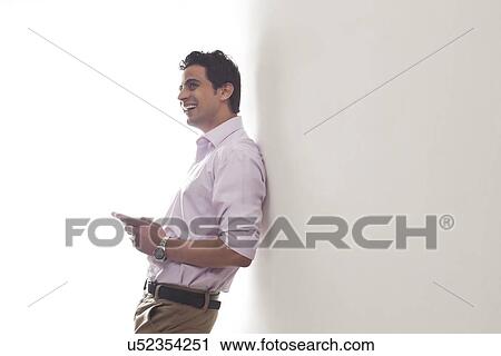 Man leaning against a wall smiling View Large Photo Image Stock Image - Man leaning against a wall smiling. Fotosearch