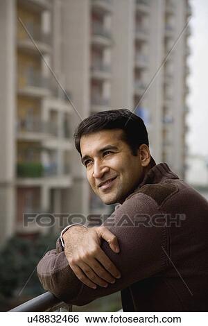 Stock Photograph - Man on a balcony smiling . Fotosearch