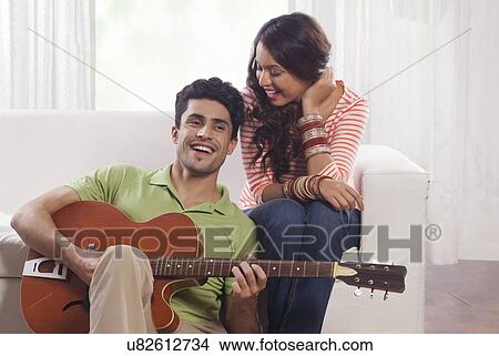 Man playing the guitar for his girlfriend View Large Photo Image Picture - Man playing the guitar for his girlfriend. Fotosearch
