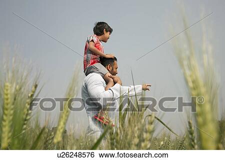 Stock Photograph - Man pointing at something while carrying little boy on shoulders . Fotosearch