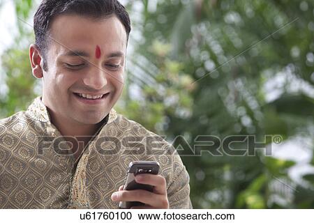 Stock Image - Man reading an sms on a mobile phone . Fotosearch