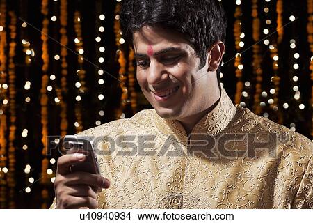 Man reading an sms on mobile phone View Large Photo Image Picture - Man reading an sms on mobile phone. Fotosearch