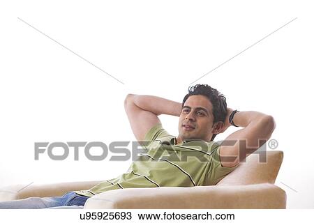Man relaxing on a sofa View Large Photo Image Stock Image - Man relaxing on a sofa. Fotosearch