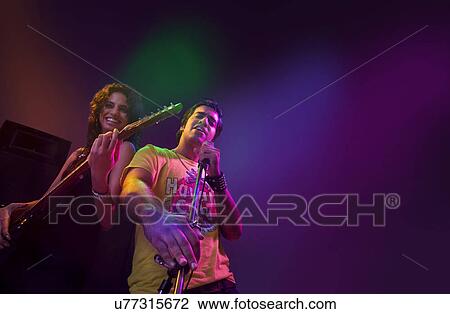 Man singing while a woman plays the guitar View Large Photo Image Stock Image - Man singing while a woman plays the guitar . Fotosearch