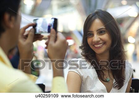 Man taking photos of beautiful woman at shopping mall View Large Photo Image Stock Photo - Man taking photos of beautiful woman at shopping mall . Fotosearch