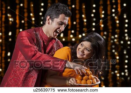 Stock Photography - Man trying to take sweets from woman. Fotosearch
