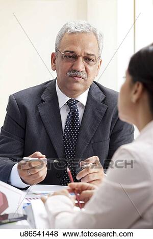 Stock Photo - Mature business man discussing with female executive . Fotosearch