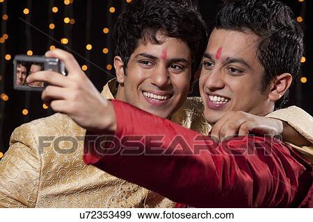 Stock Photo - Men with camera taking a self portrait. Fotosearch