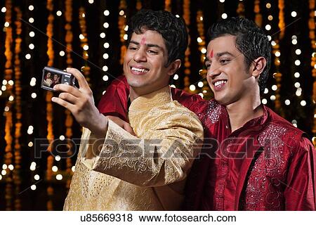 Stock Photo - Men with camera taking a self portrait. Fotosearch