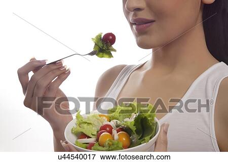 Mid section of woman eating salad of lettuce, cherry tomatoes and mushrooms isolated over white background View Large Photo Image Stock Photo - Mid section of woman eating salad of lettuce, cherry tomatoes and mushrooms isolated over white background . Fotosearch