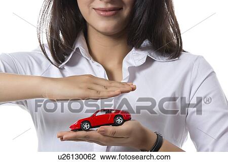 Midsection of female insurance agent holding toy car against white background View Large Photo Image Stock Image - Midsection of female insurance agent holding toy car against white background. Fotosearch