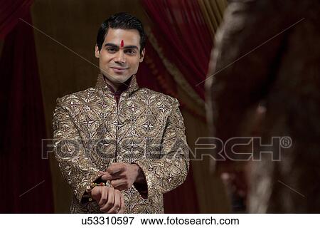 Mirror reflection of young bridegroom getting into ceremonial outfit View Large Photo Image Stock Photo - Mirror reflection of young bridegroom getting into ceremonial outfit . Fotosearch