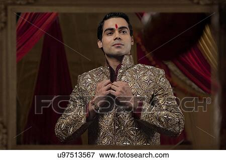 Stock Photo - Mirror reflection young bridegroom getting dressedMirror reflection young bridegroom getting dressed . Fotosearch