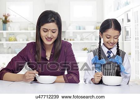Mother and daughter having breakfast at home View Large Photo Image Stock Photo - Mother and daughter having breakfast at home . Fotosearch