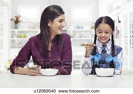 Mother and daughter having breakfast together View Large Photo Image Stock Image - Mother and daughter having breakfast together . Fotosearch
