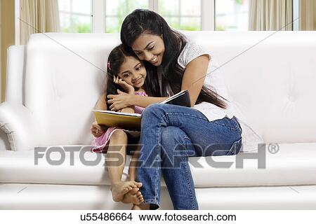 Mother and daughter reading a story book together View Large Photo Image Picture - Mother and daughter reading a story book together . Fotosearch