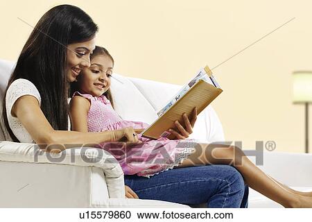 Stock Image - Mother and daughter reading a story book . Fotosearch