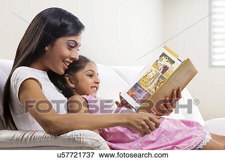 Stock Photo - Mother and daughter reading a story book . Fotosearch