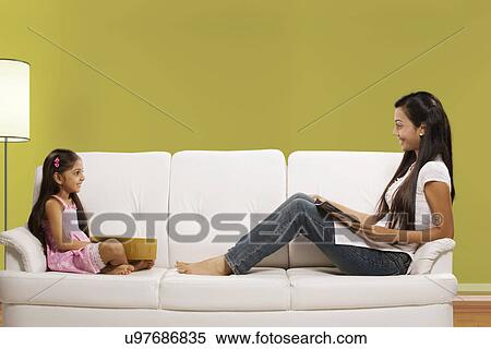 Mother and daughter sitting on a sofa View Large Photo Image Stock Photography - Mother and daughter sitting on a sofa . Fotosearch
