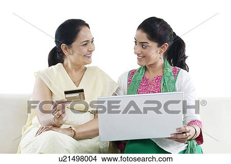 Picture - Mother and daughter with a laptop and credit card . Fotosearch