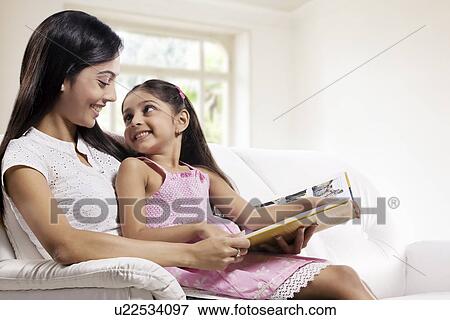 Stock Photo - Mother and daughter with a story book . Fotosearch