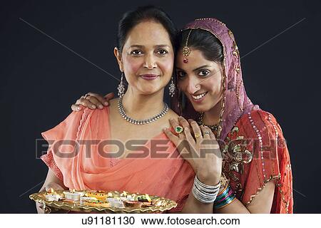 Mother and daughter with a tray of diyas View Large Photo Image Stock Image - Mother and daughter with a tray of diyas . Fotosearch