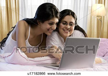 Stock Photograph - Mother and daughter working on a laptop . Fotosearch