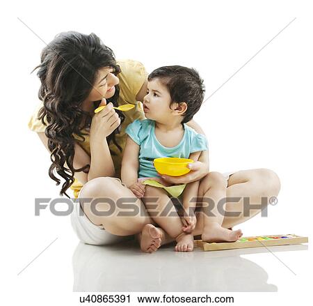 Stock Image - Mother feeding her child . Fotosearch