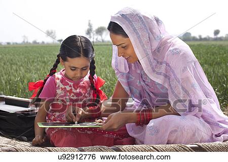Mother helping daughter with her homework View Large Photo Image Stock Photograph - Mother helping daughter with her homework . Fotosearch