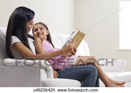 Stock Photography - Mother reading a story to her daughter . Fotosearch