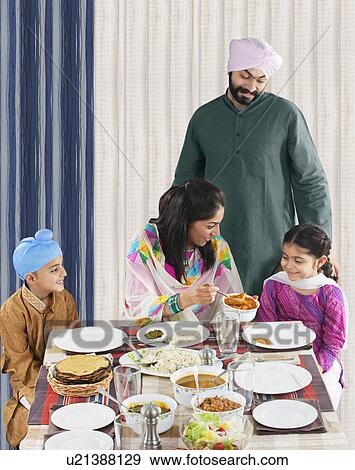 Mother serving her daughter some food View Large Photo Image Stock Photo - Mother serving her daughter some food . Fotosearch