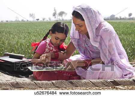 Mother teaching daughter how to write View Large Photo Image Picture - Mother teaching daughter how to write . Fotosearch