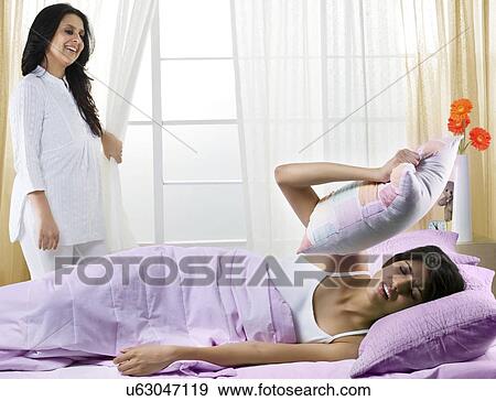 Stock Photo - Mother waking her daughter up in the morning . Fotosearch