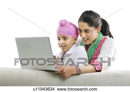 Picture - Mother with her son looking at a laptop . Fotosearch