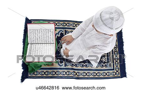 Muslim boy reading the Quran View Large Photo Image Stock Photograph - Muslim boy reading the Quran . Fotosearch