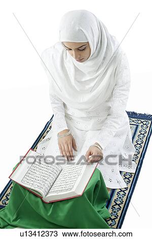 Stock Image - Muslim woman reading the Quran . Fotosearch