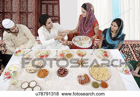 Stock Photo - Muslim woman serving food during Id . Fotosearch