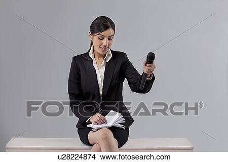 Picture - News reporter asking comment while writing in notepad . Fotosearch