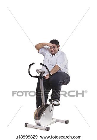 Stock Photo - Obese man on exercise bike . Fotosearch