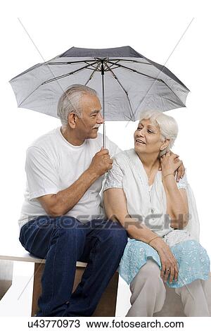 Stock Image - Old couple under an umbrella . Fotosearch