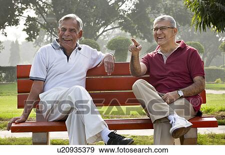 Stock Photo - Old man pointing something out to his friend . Fotosearch