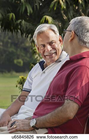 Stock Photograph - Old men sitting in a park . Fotosearch