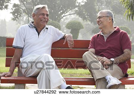 Old men sitting on a bench in a park laughing View Large Photo Image Stock Image - Old men sitting on a bench in a park laughing . Fotosearch